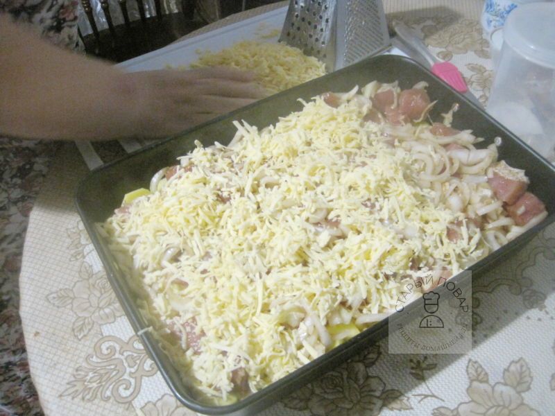 Сверху на мясо с луком высыпаем тертый сыр